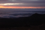 Just before sunrise, some of the lights of Colorado Springs visible through breaks in the clouds